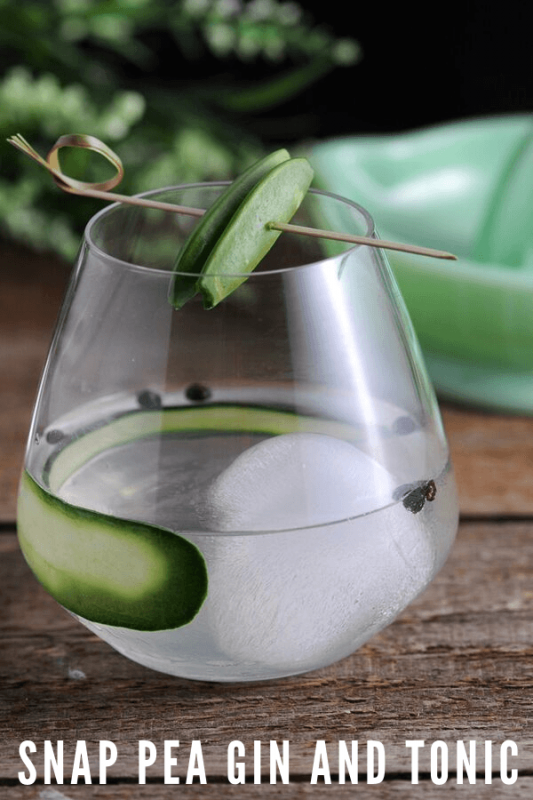 Gin and tonic glass with large ice ball, cucumber slice