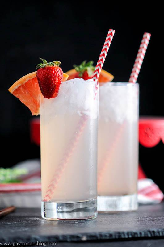 Strawberry Paloma cocktails in highball glasses with straws, strawberries and grapefruit wedges. 