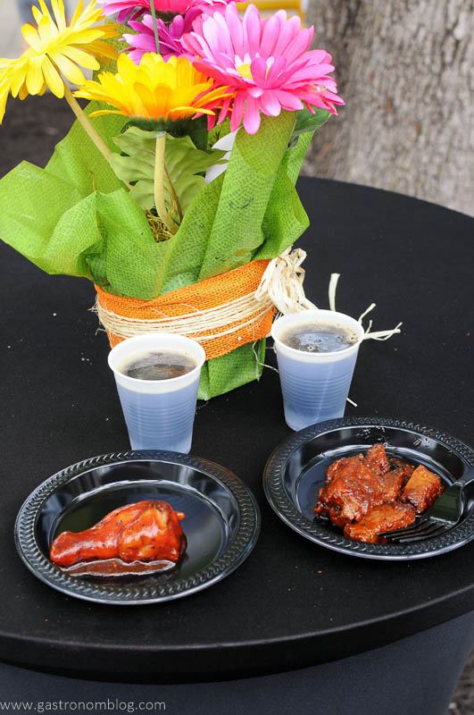 KC Flavor Festival, black plates of bbq, beer in cups, flowers behind