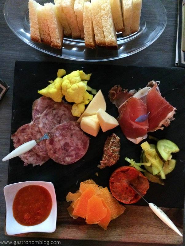 top shot of meats and cheeses on a board at SoT Kansas City. Bread on glass plate