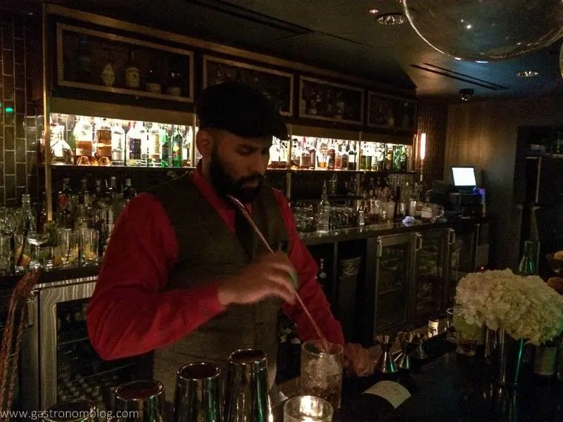 Bartender with driving cap stirring a cocktail