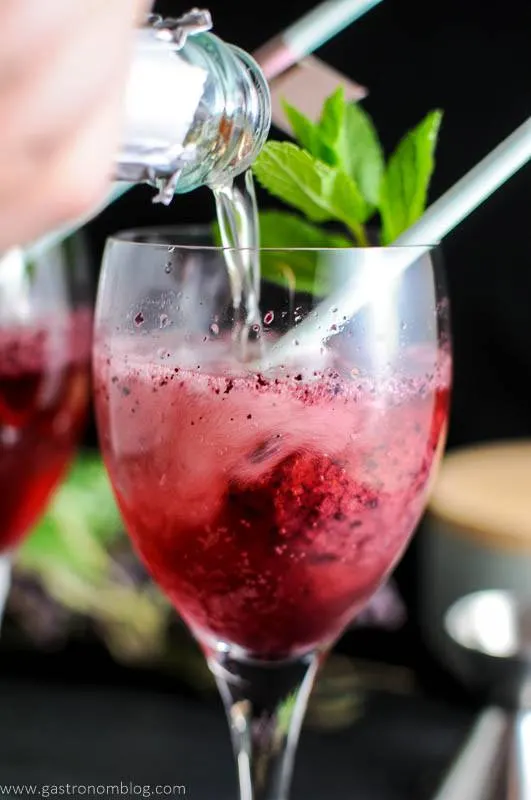 Blueberry Mint Sorbet Rose Float, red float in glass, mint and straw, wine being poured in