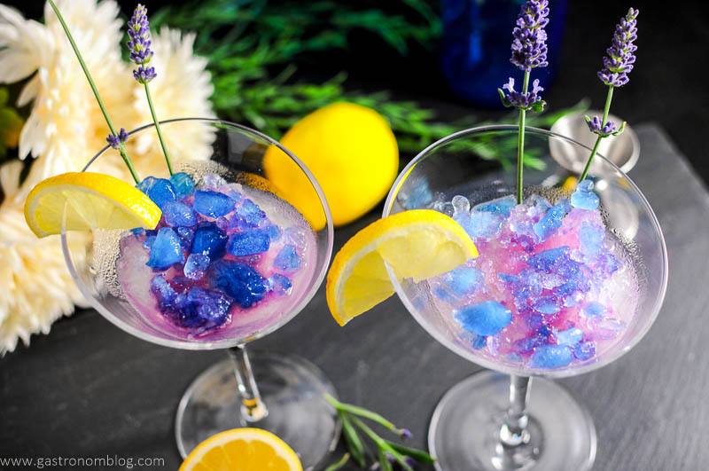 Lavender Lemon Gin and Tonic Granita Cocktail in martini glasses with flowers, lemon and jigger. Lemon slices and lavender flowers