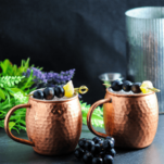 cocktails in copper mugs with grapes and ginger