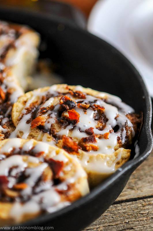 Bourbon bacon cinnamon rolls in a cast iron pan.