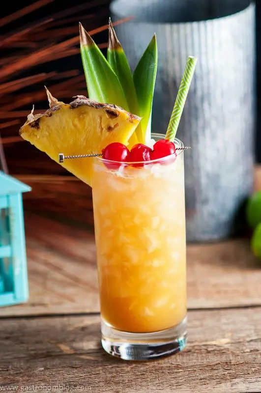 Fresh pineapple and candied cherries garnish the Fall in Paradise cocktail, a tiki cocktail full or great flavors!