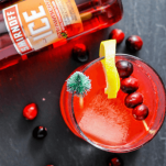 Top shot of red cocktail, cranberries and lemons with Smirnoff bottle