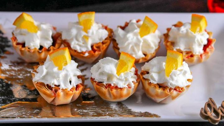 Topped with an orange wedge and whipped cream, these holiday mini berry bites are a delicious treat!