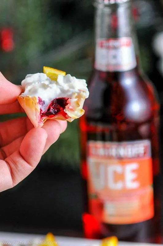 Mini Berry Bite being held in a hand. Smirnoff Ice bottle in background