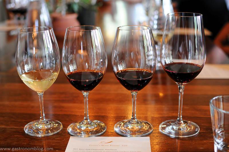 A flight of wines at Frog's Leap in the tasting room in Napa. 1 white wine and 3 red wines in glasses lined up in a row