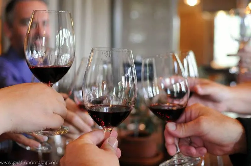 Friends toasting wine glasses together with red wine at one of the great Napa Valley Wineries