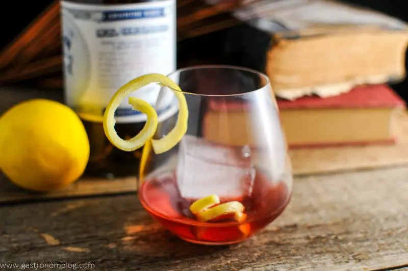 Detail hsot of a blackberry sazerac, St George Spirits Absinthe Verde and books.