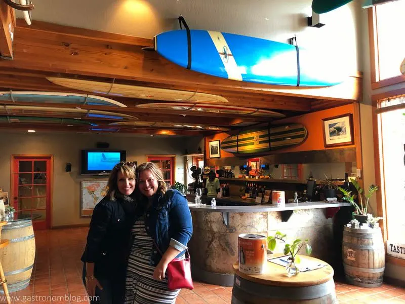 2 women in the out the Surflounge at Longboard Vineyards! Surfboards on ceiling, barrels as tables around the room