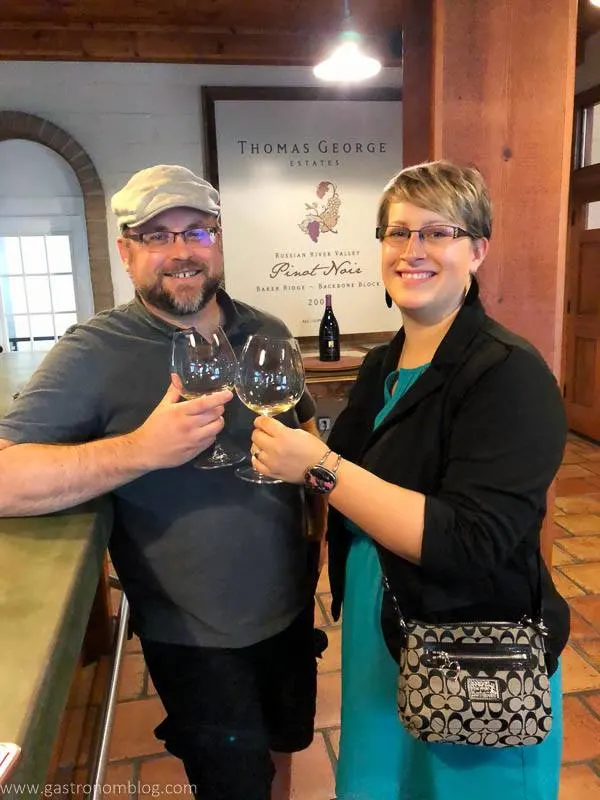 Jay and Leah Hall visit. Thomas George Estates. We are clinking glasses while smiling.