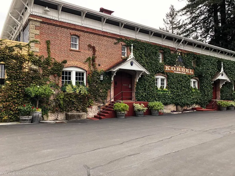 The Korbel Winery tasting room building outside. Red brick building with white trim, ivy growing on brick.