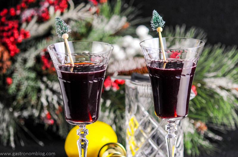 Recap Cocktails in fluted glasses. Pine tree topped cocktail stirrers. Fir branch, mixing glass and lemon in background