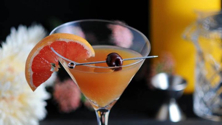 Apple Cider Sidecar in a martini glass with brandied cherry and a grapefruit ganish.