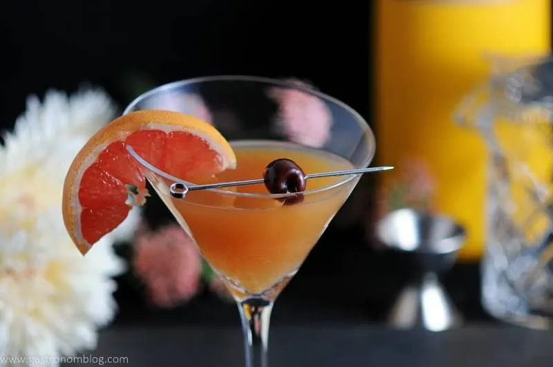 Apple Cider Sidecar in a martini glass with brandied cherry and a grapefruit ganish.