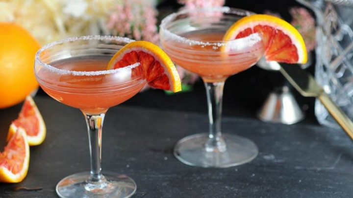 Blood orange sidecars in vintage cocktail coupe and garnished with blood orange wheels.