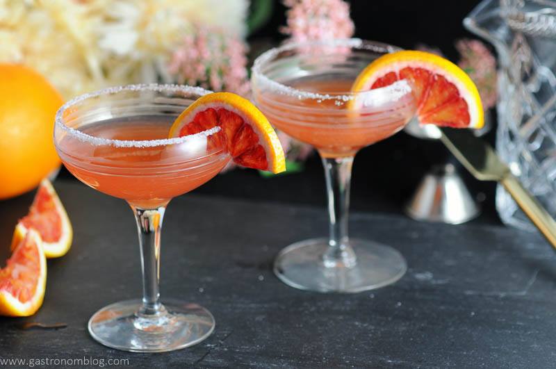 Blood orange sidecars in vintage cocktail coupe and garnished with blood orange wheels.