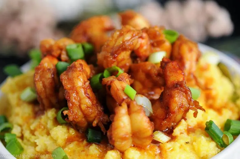 Fresh chopped chives top bourbon shrimp made with World Port Seafood Wild Argenytinian Red Shrimp and cheesy grits in a hearty southern meal.