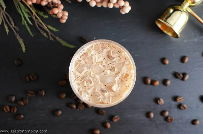 A Chai Toasted Cream White Russian sits in a rocks glass surrounded by coffee bean garnishes!