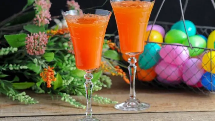 Two Carrot Ginger Mimosas in Rolf Glass Gatsby Cocktail Flutes and spring flowers and easter eggs