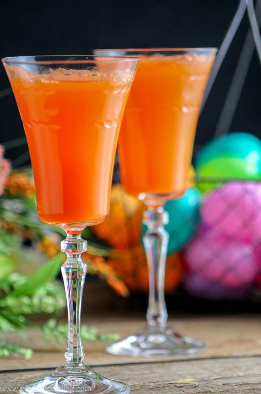 Two Carrot Ginger Mimosas in Rolf Glass Gatsby Cocktail Flutes and spring flowers and easter eggs