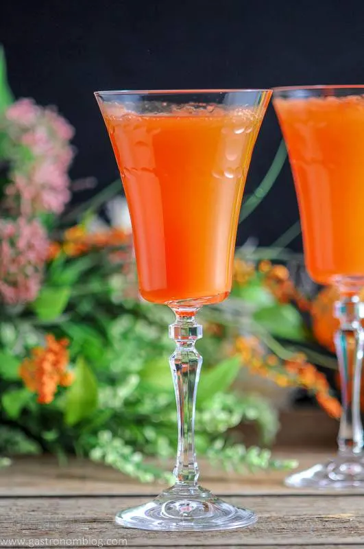 Two Carrot Ginger Mimosas in Rolf Glass Gatsby Cocktail Flutes and spring flowers and easter eggs