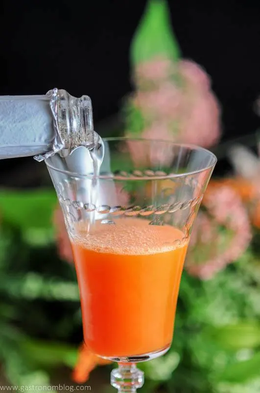 Brut Champagne poured into fresh carrot juice, ginger liqueur, and spiced orange syrup to make the Carrot Ginger Cocktail - an easter cocktail.