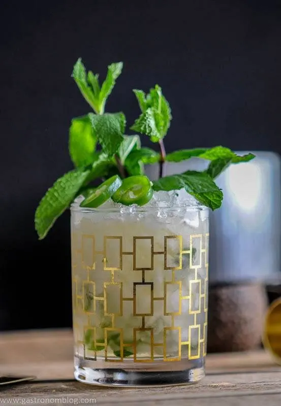 The Mexican Mint Julep is a mezcal cocktail served in a rocks glass and topped with jalepeno and fresh mint.
