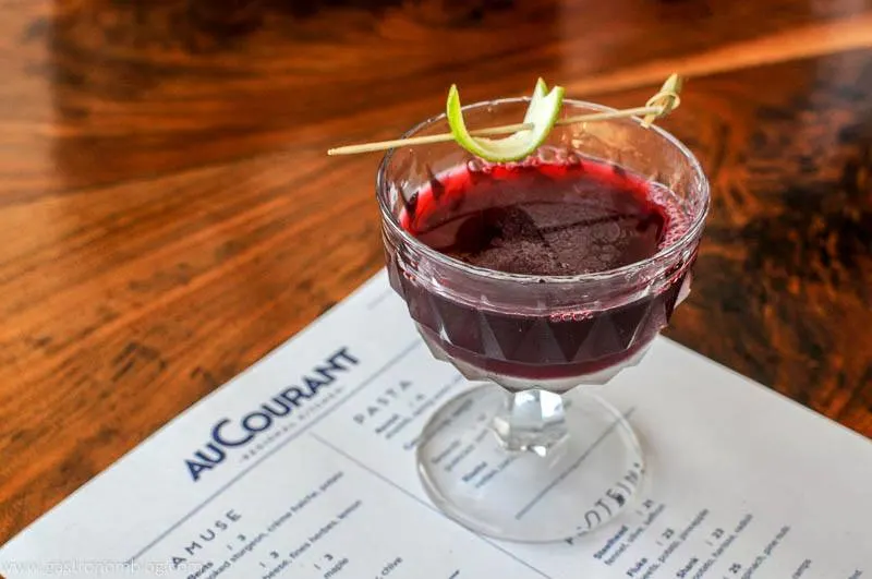 purple Cocktail at AuCourant in Omaha Nebraska, lime peel on pick