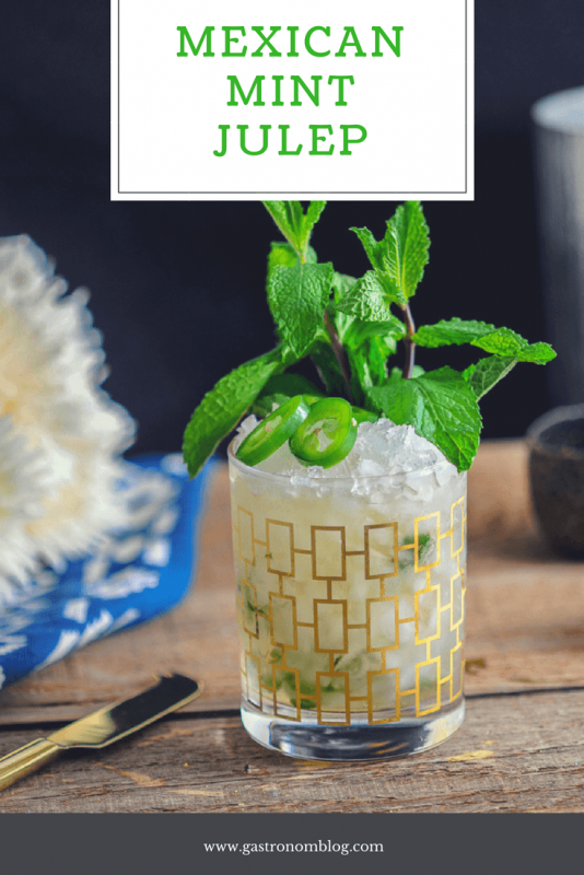 Mexican Mint Julep in gold trimmed rocks glass. Mint and jalapenos on ice. White flowers in background