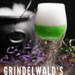 Green cocktail with dry ice on top, cauldron with dry ice in the back