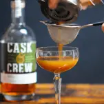 Cocktail being poured into coupe