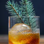 Cocktail with ice ball and pine branch