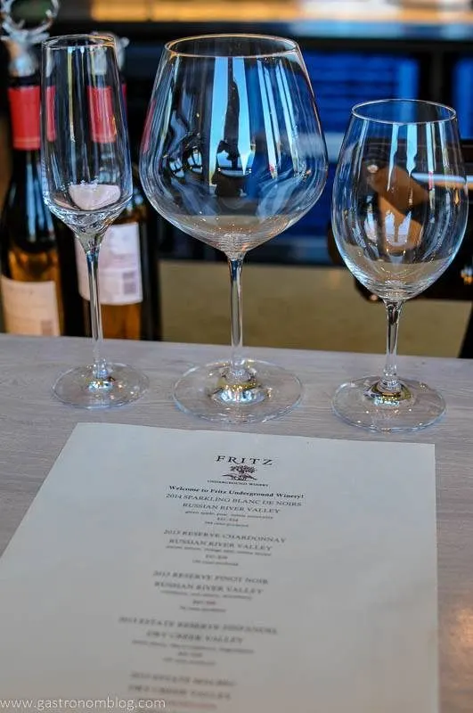 A tasting menu and wine glasses sit on the bar of the tasting room at Fritz Underground Winery.
