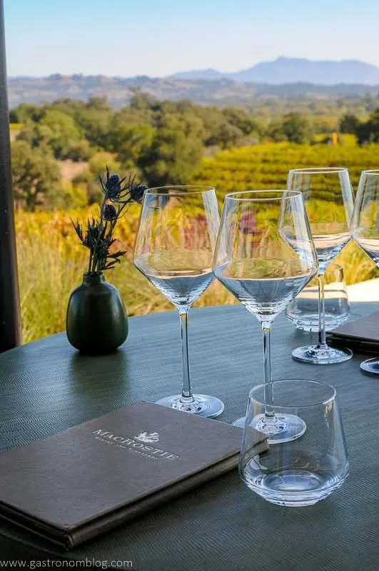 Wine glasses and a tasting menu sit at a table for tasting at MacRostie Vineyards.