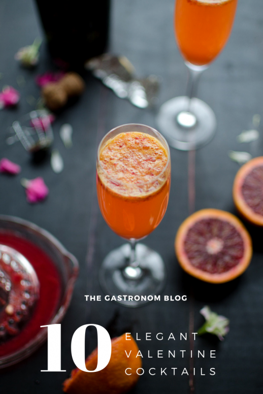 Top shot of orange champagne cocktail, blood orange slices and champagne bottle