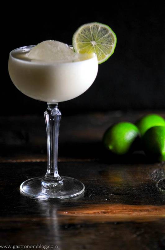 White Chocolate Martini in a coupe glass with ice ball, lime wheel, limes in background