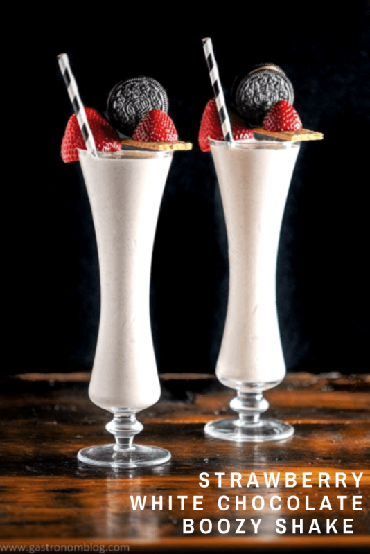 Strawberry Milkshakes in tall glasses with straws, strawberries, and oreo cookies!