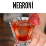 Pink cocktail in square glass with strawberry on rim
