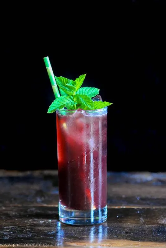 Red cocktail with mint and straw