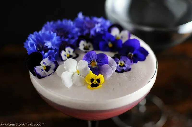 Egg white foam topped cocktail with edible flowers