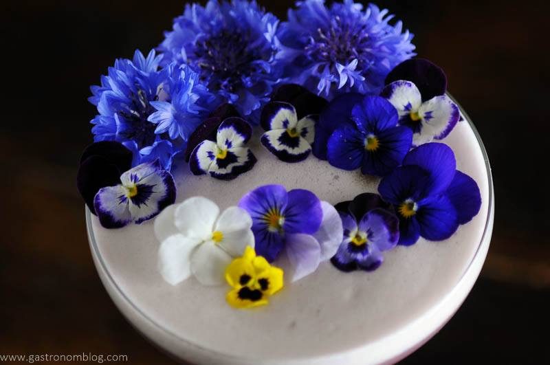 Egg white cocktail foam topped with edible flowers