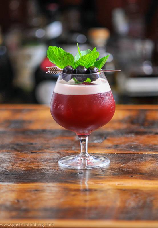 Maroon cocktail with mint and cherries