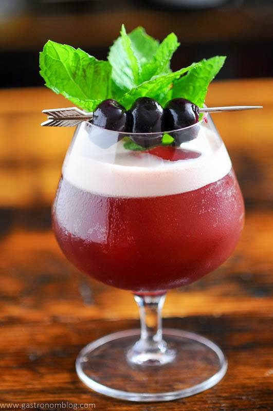 Red cocktail with mint and cherries