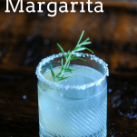 White margarita in a rocks glass with salt rim and rosemary sprig