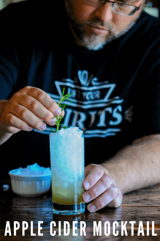 Man placing straw in highball drink