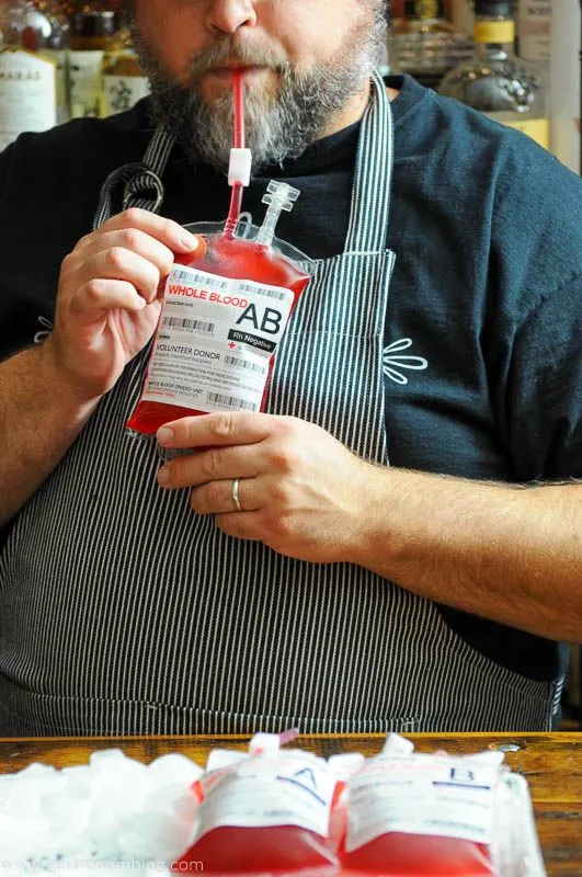Man holding iv bag with red cocktail inside